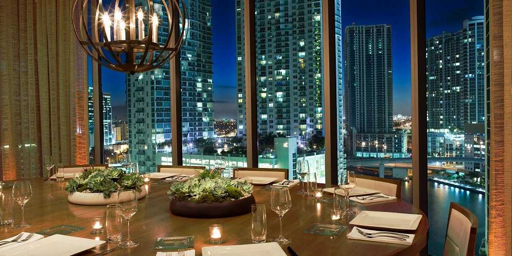 Area 31 Restaurant in Miami: A rooftop dining room in Miami with a stunning view of the city at night.