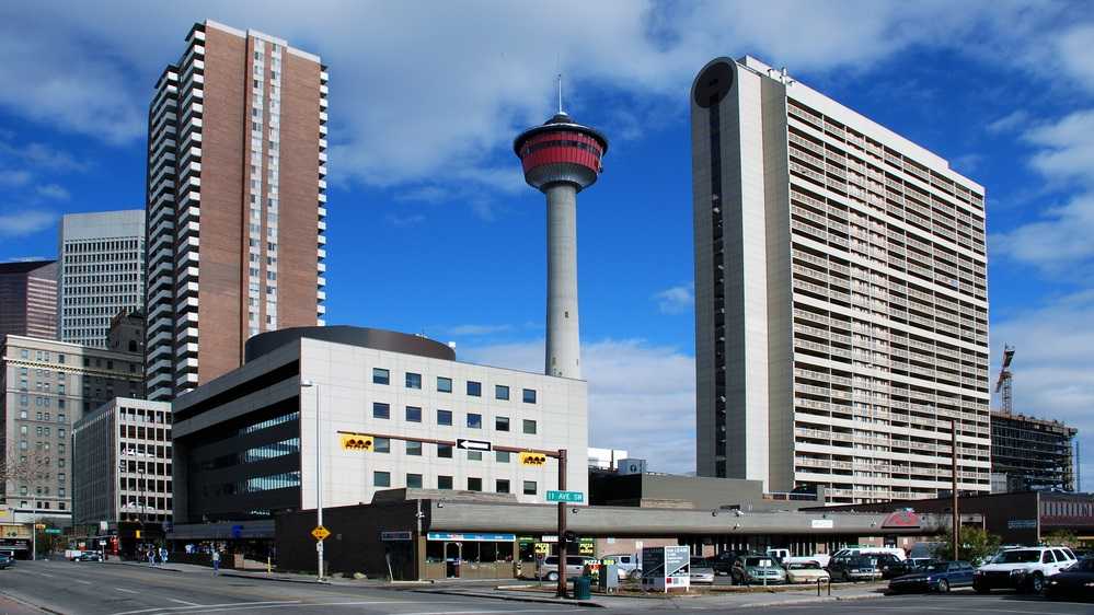 Best things to do in Calgary including a city street with tall buildings and a clock tower.