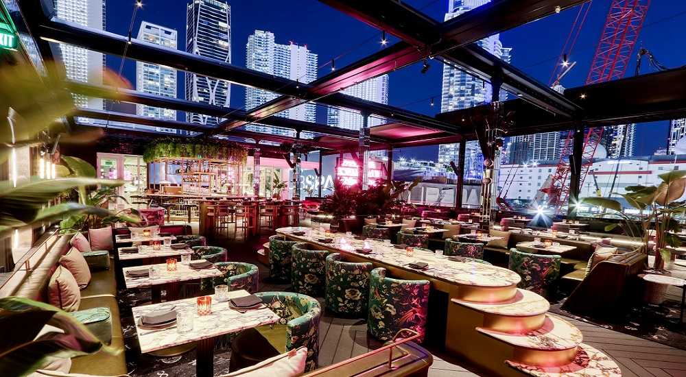 Giselle Miami Restaurant: A rooftop restaurant in Miami with tables and chairs amidst the bustling cityscape.