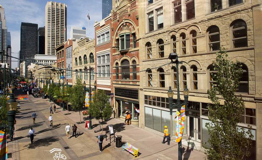 Best things to do in Calgary include exploring city streets with tall buildings and observing people walking down the street.