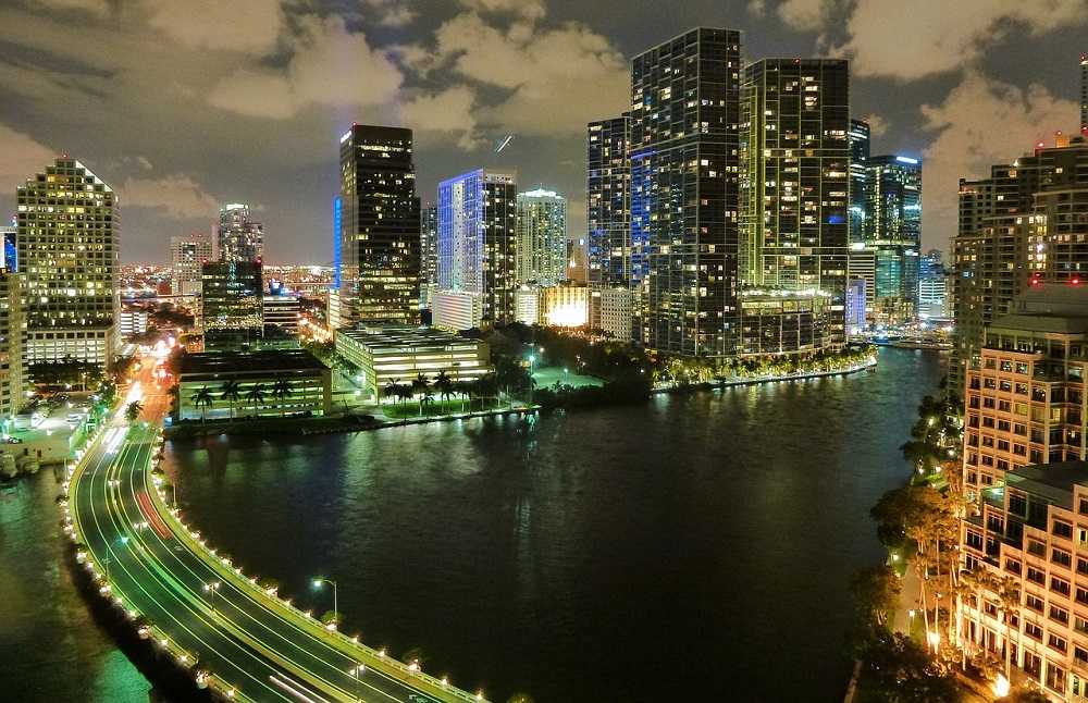 Attractions in Downtown Miami: A city skyline at night with a river in downtown Miami.