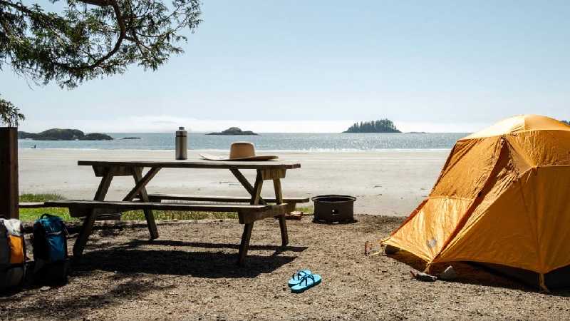 A yellow tent sits on the beach at a campgrounds on Vancouver Island.