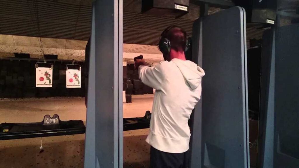 At West Edmonton Mall attractions, a man is skillfully shooting a gun in a shooting range.