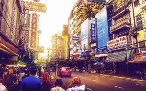 A bustling street in Bangkok with a constant stream of people walking down it, showcasing some of the attractions in this vibrant city.
