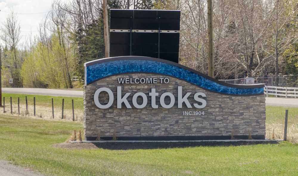 A welcome sign at the entrance of Okotoks, one of the best places to live in Alberta, indicating the town's incorporation in 1904.