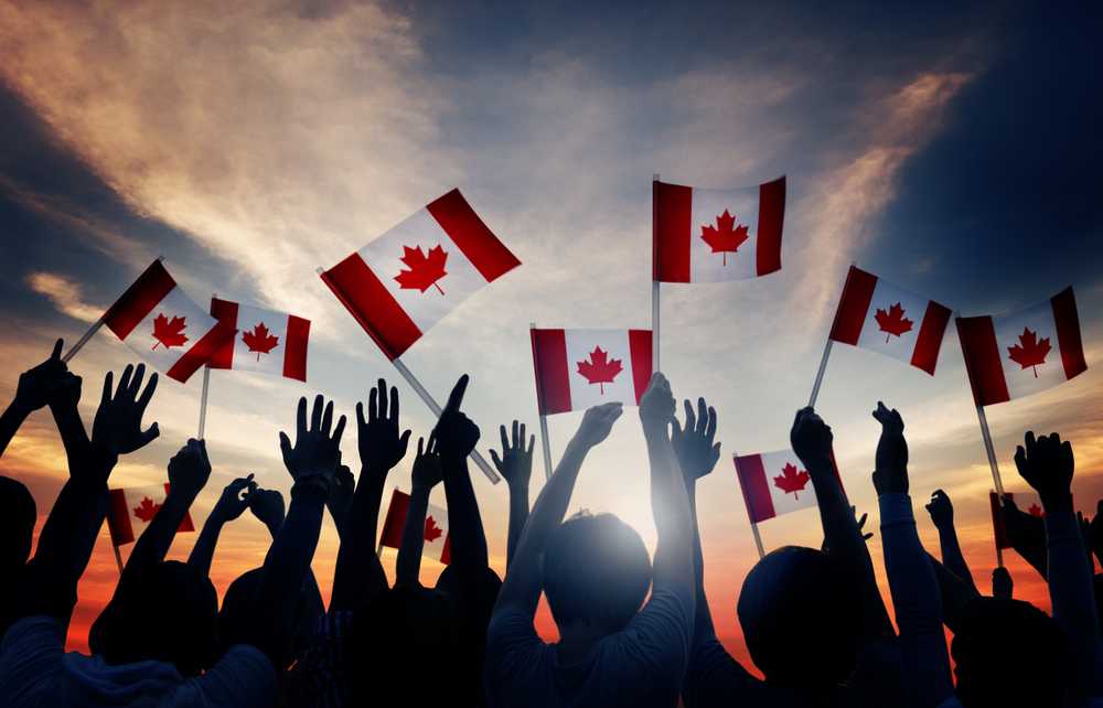 A group of people holding flags, showcasing fun facts about Canada.