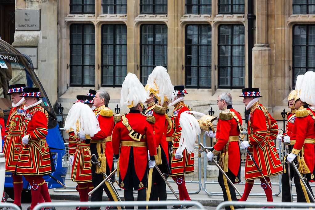 A group of men in red uniforms, symbolizing interesting facts about Canada, standing in front of a building.