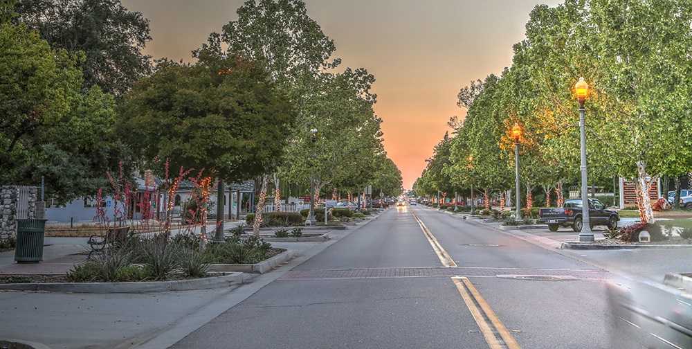 A street with trees on the side, in one of the safest cities in America.