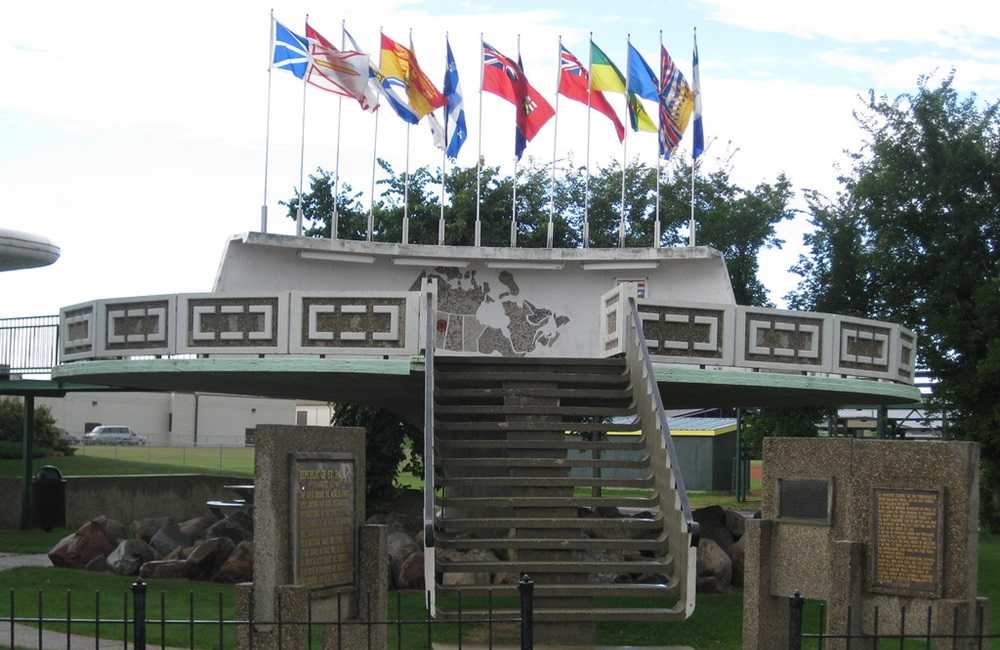 A staircase adorned with Alberta flags leading to a building.