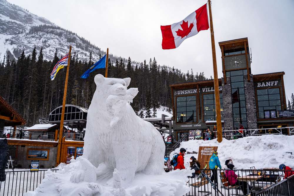 a white bear statue in front of a building with a flag
